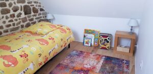 Chambre enfant en mezzanine avec lit, livres et lampes de chevet