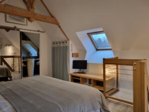 Chambre parentale sous charpente apparente, ouverte sur la salle d'eau de l'étage